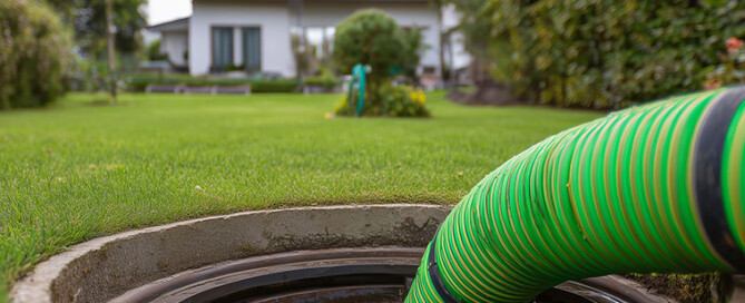 Bild eines geöffneten Sickerschachtes, der mit einem Hochdruckschlauch von den Verunreinigungen des Winters gereinigt wird (Foto: © TensorSpark, Adobe Stock)